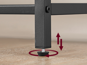 Bútor lábbeállító mechanizmusának közeli képe. Fekete fémkeret piros kör alakú talppal és egy függőleges mozgást jelző nyíllal.