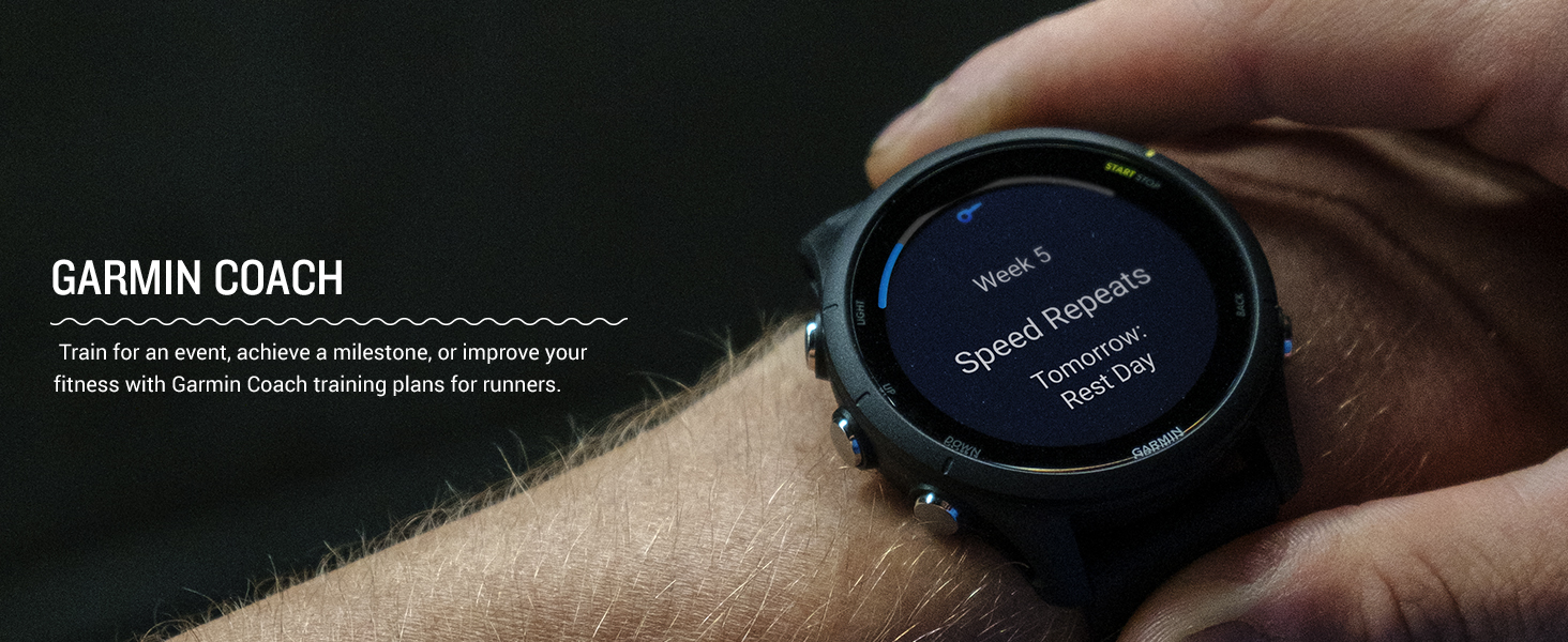 Garmin Forerunner 255 Music smartwatch on a wrist showing Garmin Coach training plan with Week 5 Speed Repeats and a rest day tomorrow.