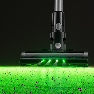 Černá hlava vysavače s osvětlenými zelenými LED světly ukazujícími nečistoty na povrchu podlahy během čištění.