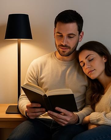 Warm table lamp o with a couple sitting beside it, reading a book together in a cozy room setting.