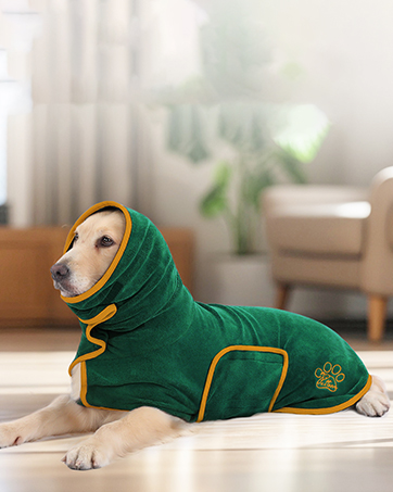 PETTOM 2 Pcs Dog Towel Quick Drying Absorbent Microfiber Dog Towel Artero, Bath Towels with Pockets for Small, Medium and Large Dogs, 90 x 50 cm 21 Perro con una chaqueta verde con capucha y ribete amarillo. La chaqueta cubre el cuerpo y la cabeza del perro, dejando la cara expuesta. El perro está tirado en el suelo en un entorno hogareño.