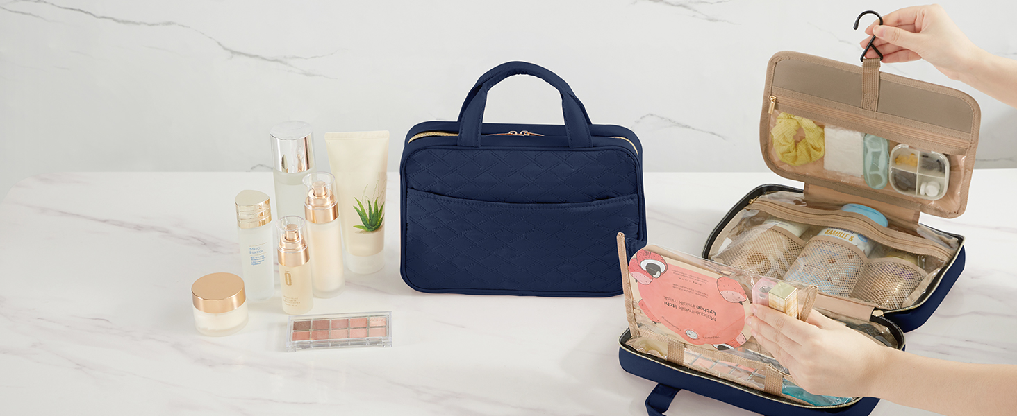Navy blue travel organizer bag opened to reveal multiple compartments. Contains toiletry bottles and accessories. Closed bag and additional containers visible.