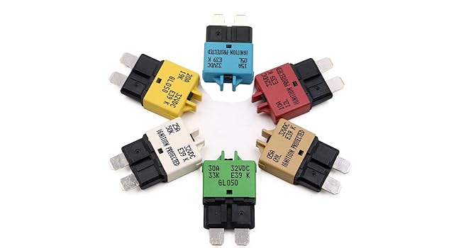 Six colorful circuit breakers arranged in a circle. Each breaker has a different color: yellow, blue, red, white, tan, and green. They feature metal prongs and plastic housings.