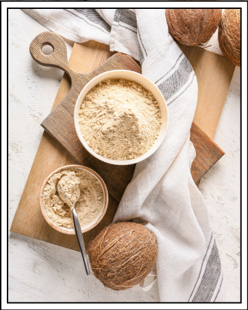 Bols de farine de noix de coco et de noix de coco entières sur une planche de bois avec un chiffon blanc. Une cuillère dans un petit bol suggère une utilisation culinaire.