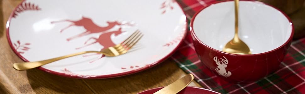 Holiday table setting with red and white plates featuring reindeer design on red plaid tablecloth. Gold utensils and small coordinating dish visible.