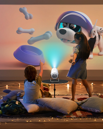 Installation artistique extérieure illuminée mettant en vedette de grandes figures sculpturales bleues sur fond de ciel couchant, avec une rangée de lampes au sol créant une ambiance spectaculaire.