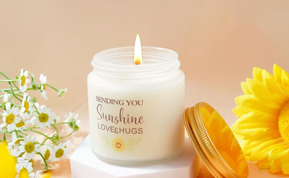 Kerzenglas aus weißem Milchglas mit Aufschrift „Sending You Sunshine Love & Hugs“, beleuchteter Docht, präsentiert mit Gänseblümchen