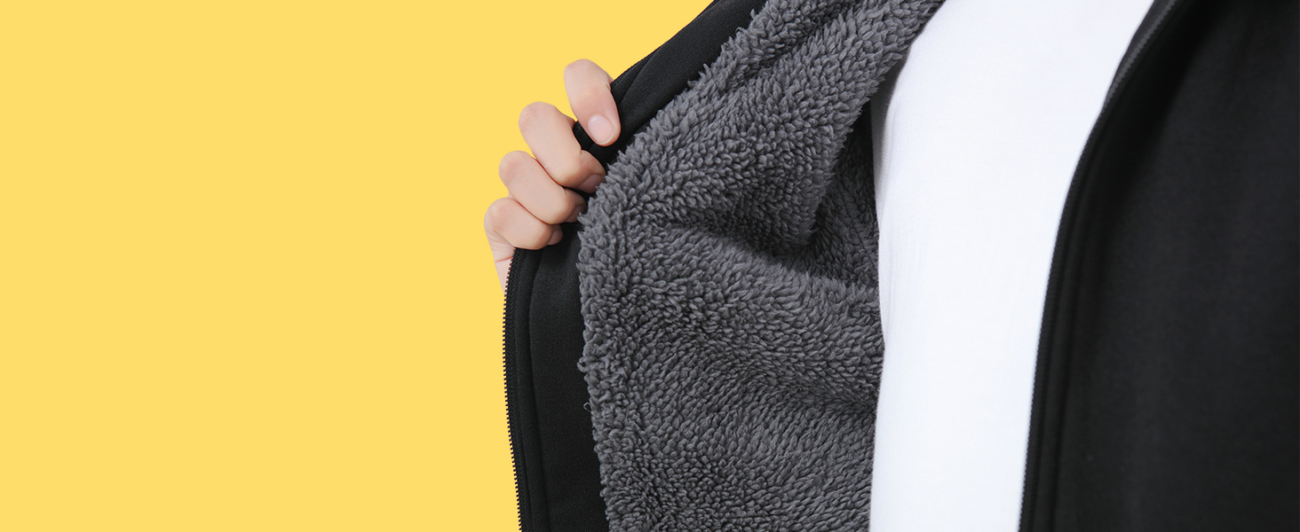 Nahaufnahme eines schwarzen Kleidungsstücks mit flauschigem Innenfutter oder Fleece-Innenfutter, das offen gehalten wird, um die Textur zur Geltung zu bringen