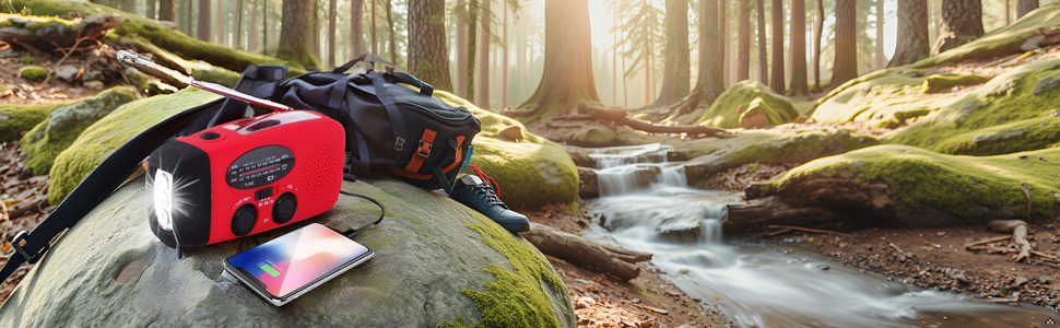 A rugged emergency radio sitting on a wooden table in a dimly lit room, with a flashlight beam illum