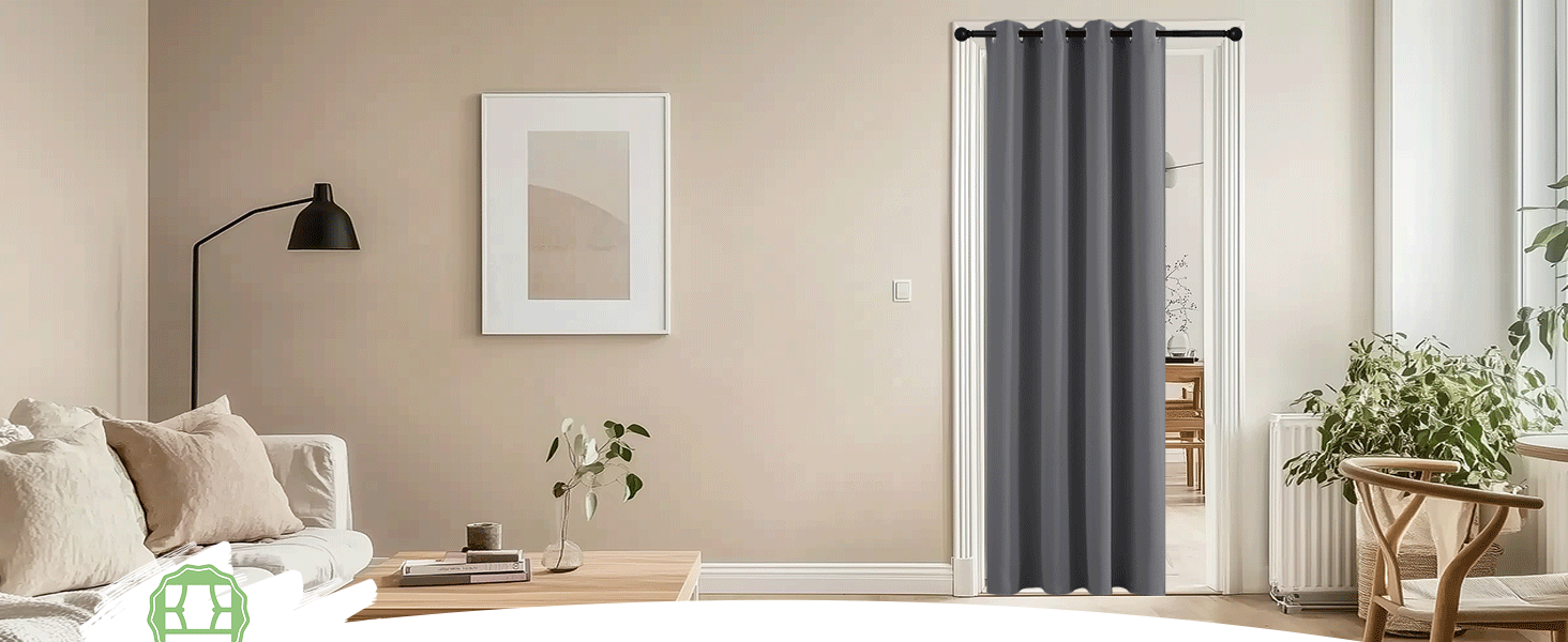 Modernes Wohnzimmer mit einem grauen Verdunkelungsvorhang mit Ösen sowie beigen Wänden, Zimmerpflanzen und minimalistischem Dekor.