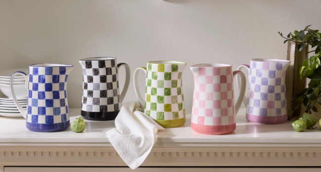 Stoneware check pitchers in blue, black, green, pink, and lavender.