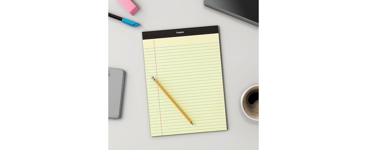 yellow notepad on desk with pencil on top