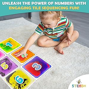 child playing with numbered liquid sensory tiles while sitting on the carpet