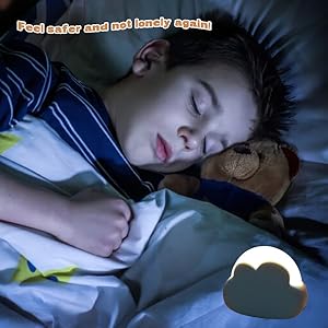 un enfant qui dort dans un lit avec un ours en peluche