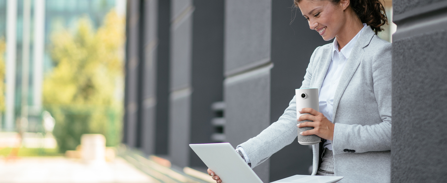 a woman holding a cup of coffee and a laptop