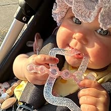 Die Prinzessin greift mit beiden Händen nach dem Beißring