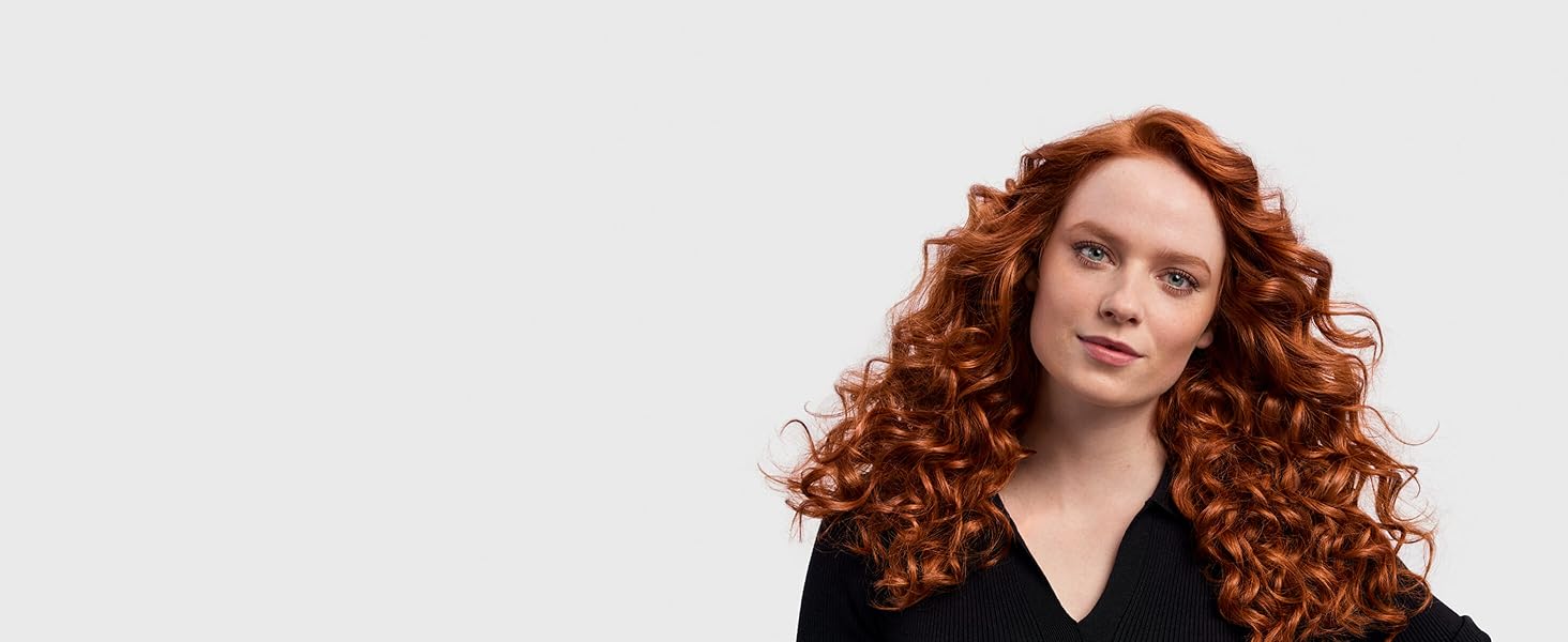 Ein Model mit rotem Haar und Locken im 80er-Jahre-Look