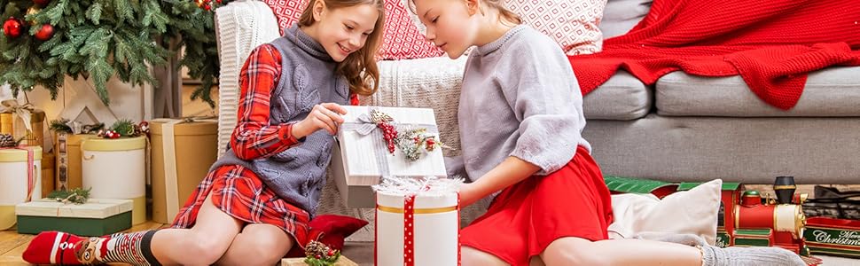 Christmas scene with wrapped presents and decorations on floor, showing close-up view of holiday gift arrangement against blurred background.