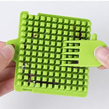Bright green plastic pet grooming tool with grid-like pattern of flexible bristles, held between thumb and forefinger to demonstrate size and flexibility.