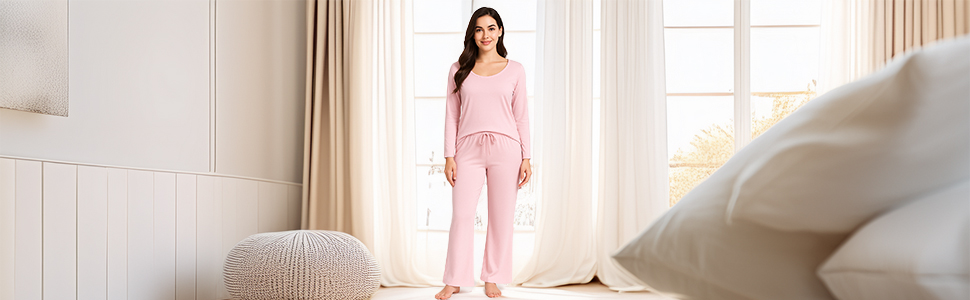 Woman in pink HAVENORA pajama set with scoop neck top and flared pants in cozy bedroom