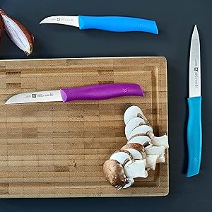 Knife and sliced mushrooms on a wooden cutting board.