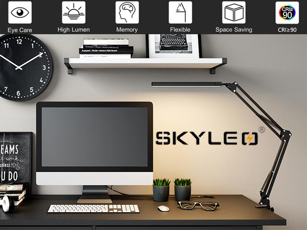 a desk with a computer and a clock on it.