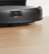 Nahaufnahme eines dunkelgrauen Roboterstaubsaugers auf einem Holzboden. Kreisförmige Form mit sichtbarem Stoßfänger und Sensor an der Vorderkante