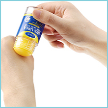 Close-up of hand holding a small blue product container against white background.