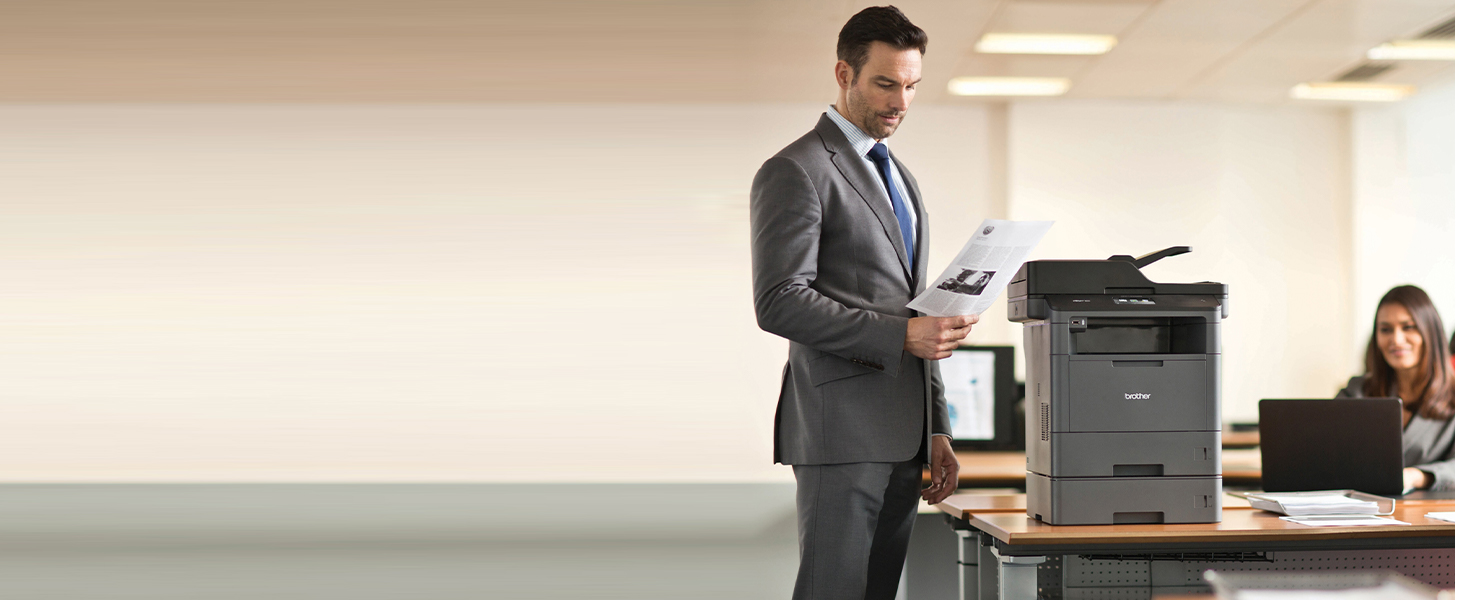 Man in corporate office reviewing report printed from MFCL5705DW business monochrome laser printer