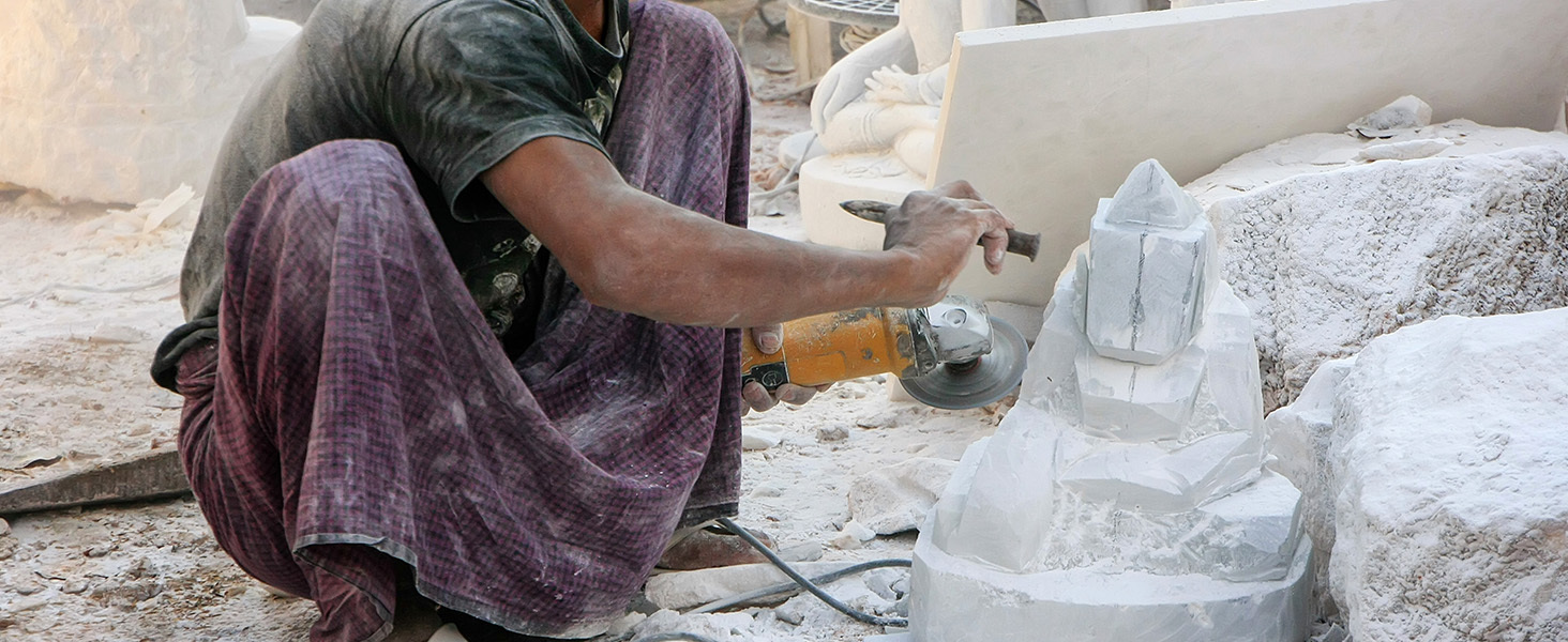 man working on a marble statue in india