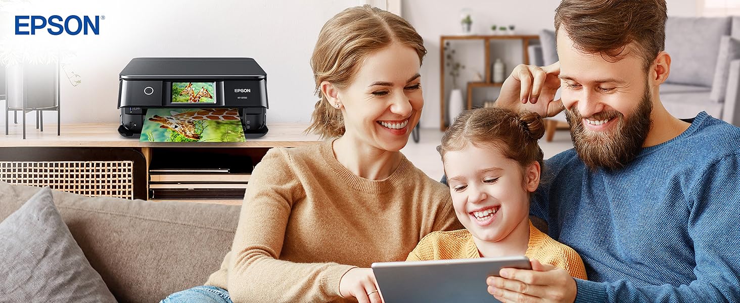 Family seating on a sofa, looking at a tablet with a printer behind them