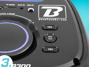 Primer plano del panel de control de un dispositivo de audio negro con la perilla de volumen iluminada, los botones de reproducción y la marca «Boomtonedj.com» visible. Se muestra parte de una etiqueta del modelo «T3.3800».