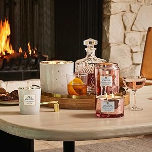 Sparkling Rose and Bourbon Vanille candles on a table in front of a fireplace
