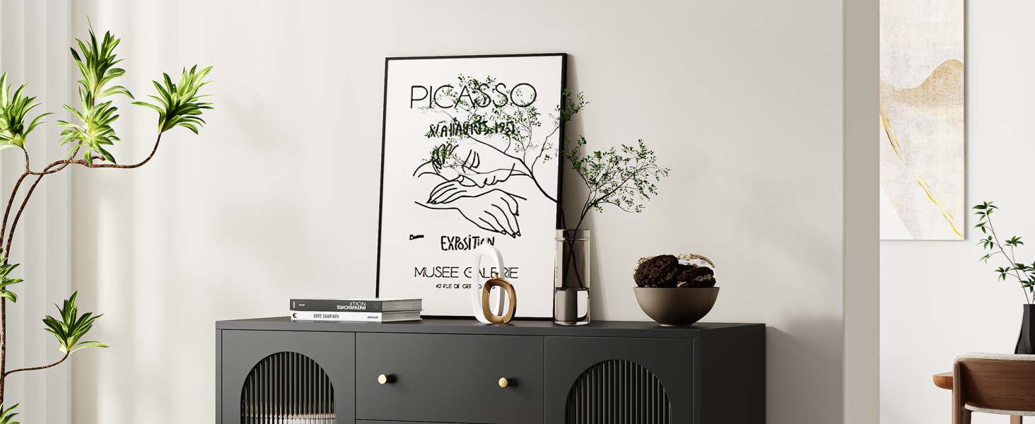 Schwarzer Schrank mit gerippten Türen, verziert mit Dekorationsgegenständen wie einer gerahmten abstrakten Skizze, Pflanzen und kleinen Objekten in einer minimalistischen Inneneinrichtung