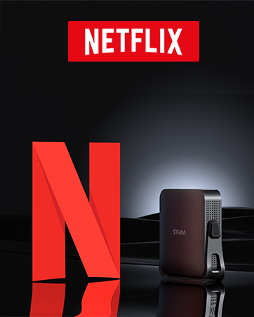 Netflix logo and 'N' symbol displayed prominently. A small, dark-colored streaming device with perforated surface visible in the corner, likely for Netflix streaming.