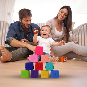 A baby and their parents are playing tossing games with blocks