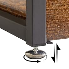 Gros plan du pied de meuble avec pied métallique réglable. Le cadre en métal foncé contraste avec la surface en bois. La flèche indique la rotation pour le réglage de la hauteur.