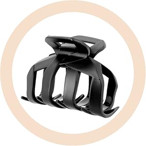 Grande pince à cheveux en plastique noir avec de larges dents et un design incurvé, représentée sur un fond circulaire de couleur pêche