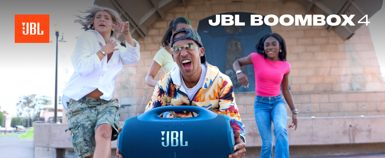 Le texte indique « JBL BOOMBOX 4 ». Bannière marketing montrant plusieurs personnes dansant et écoutant de la musique en plein air, avec un grand haut-parleur portable arborant la marque JBL distinctive.