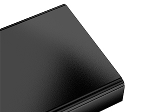 Corner view of a sleek, black rectangular electronic device with a smooth surface, possibly a laptop or external hard drive.