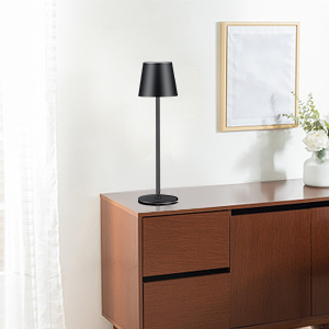 Modern bruin houten dressoir met zwarte tafellamp en decoratieve spiegel erboven. Witte vaas met bloemen geeft een accent aan een minimalistische meubelopstelling.