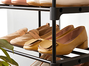 Muestra de mocasines de cuero tostado dispuestos en una estantería de metal, que muestra varios pares de zapatos casuales