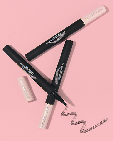 Three black liquid eyeliner pens with fine tip applicators and two white pencil-shaped products on a pink background. One eyeliner shows a curved line sample.