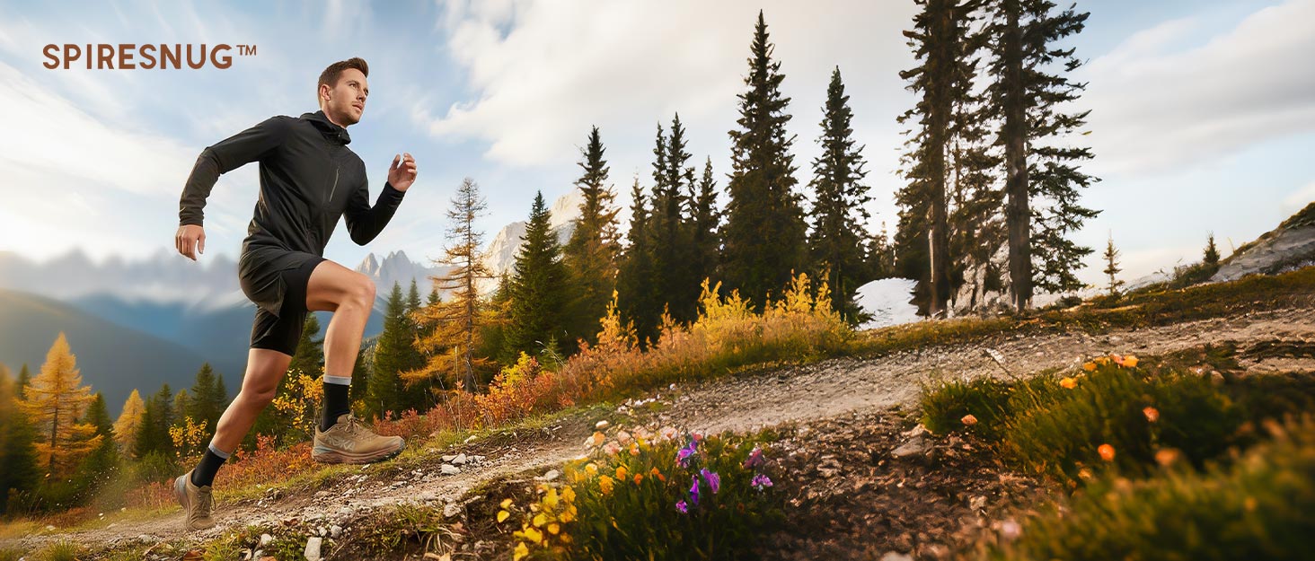 SPIRESNUG man running on mountain trail with pine trees. Performance socks and shoes.