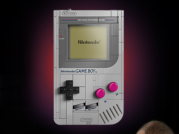 Text reads 'Nintendo' on classic Nintendo Game Boy device shown in gray color against dark background with dramatic lighting.