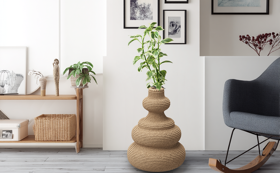 This living space has a tiered woven vase with a green plant, and framed art on the walls