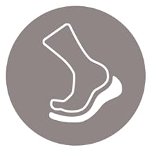 Icono circular gris con contorno blanco de un pie y un tobillo, que posiblemente indique calzado o un producto o servicio relacionado con los pies