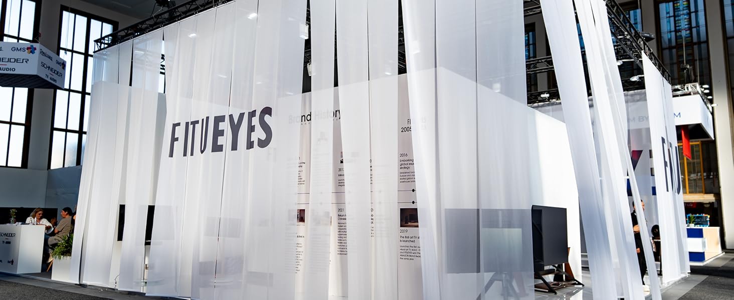 Large white translucent installation structure in industrial space with 'FIDEYES' text visible, featuring vertical hanging panels and dramatic lighting.
