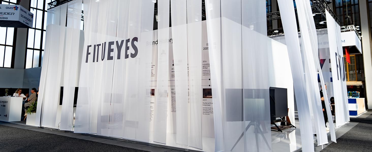 Large white translucent installation structure in industrial space with 'FIDEYES' text visible, featuring vertical hanging panels and dramatic lighting.