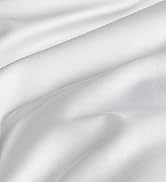 Close-up of white, silky fabric with soft folds and creases, showing a smooth and luxurious texture.